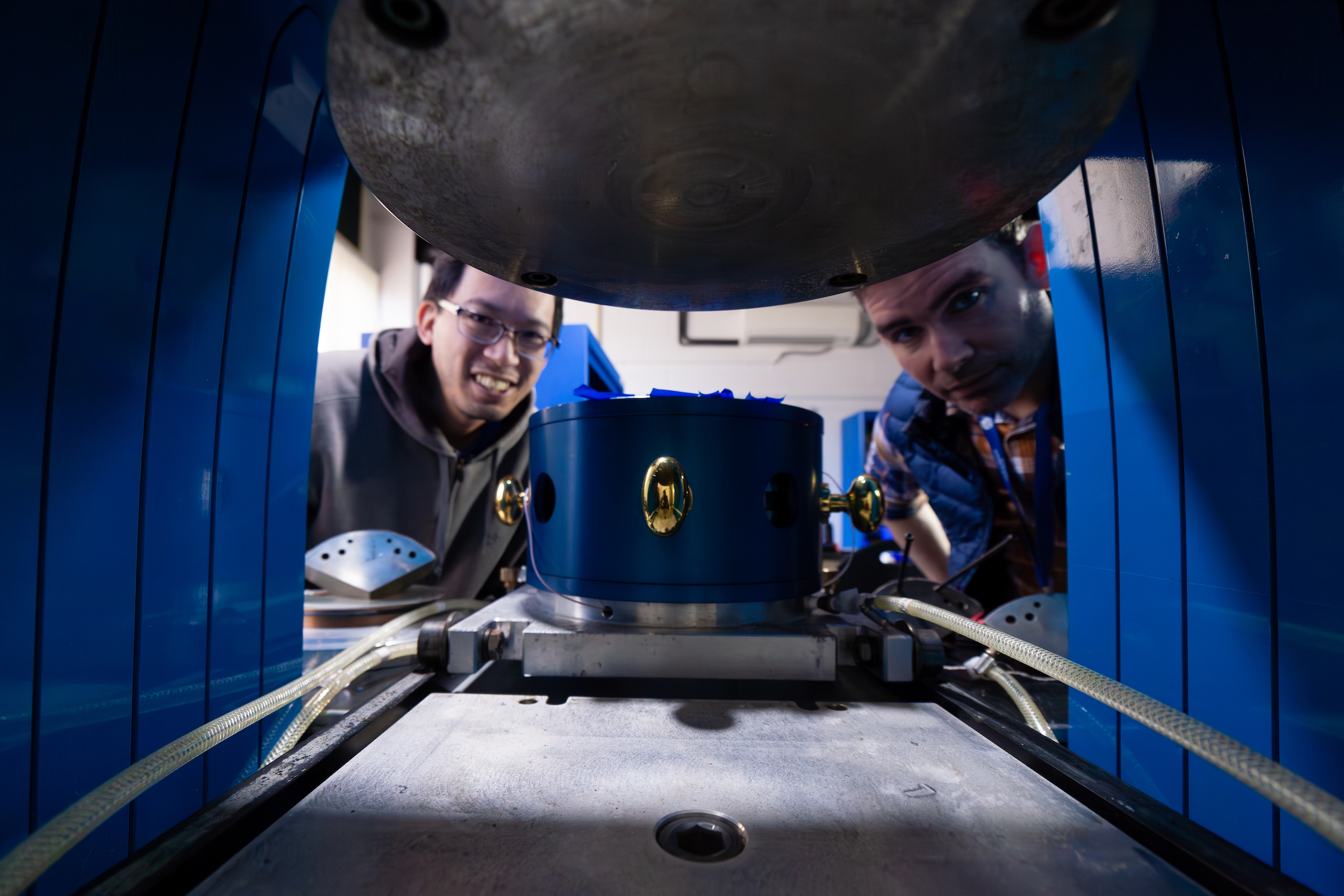 Instrumentation Engineer Joseph Lai and Laboratory Engineer Javier Rojas pose for a photo as they work to calibrate the 1100-ton Rockland multi-anvil press. 