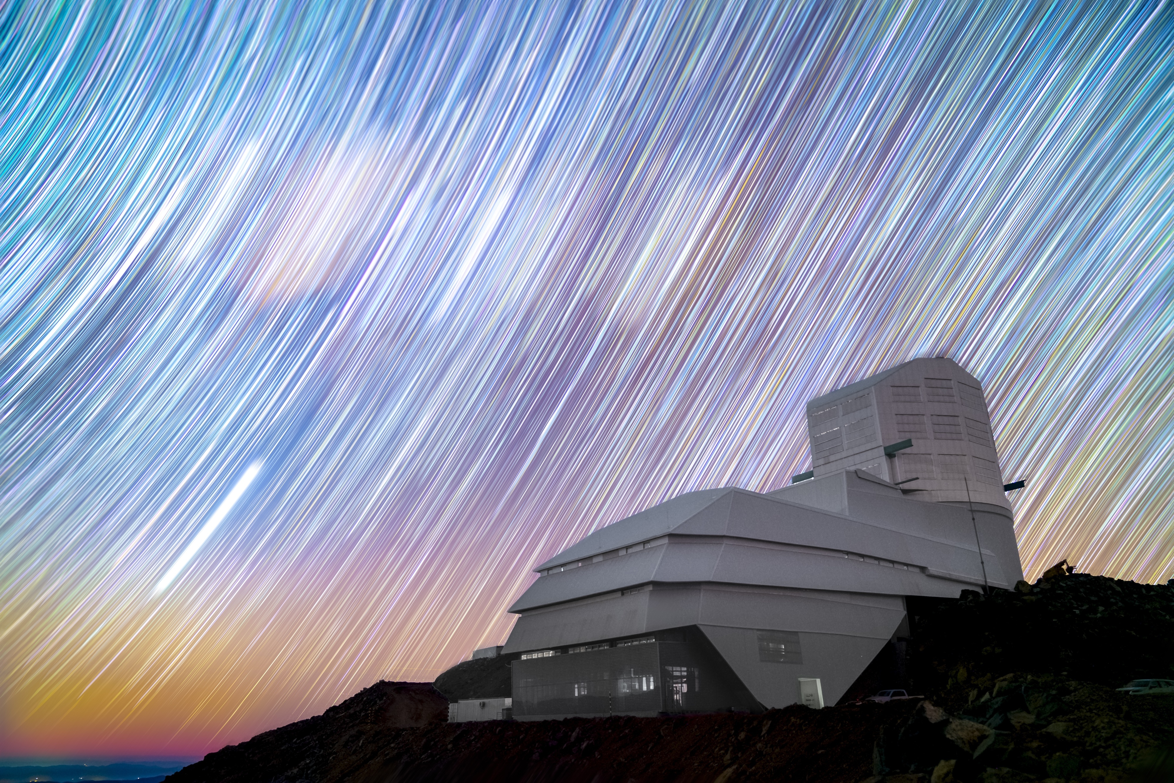 Rubin Observatory stands on Cerro Pachón in Chile against a sky full of star trails in this long exposure night sky image.