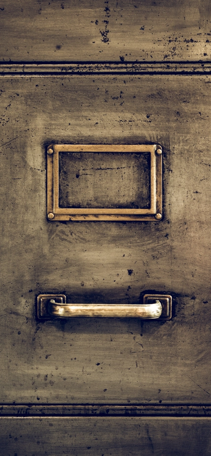 the front of an old file cabinet without a paper label in the metal frame