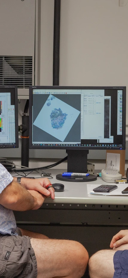 Larry Nittler and Jens Barosch pose for a photo as they scan a sample of the Ryugu asteroid