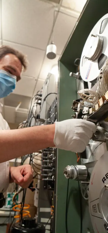 Steven Golden carefully feeds the tape through the machine reader. Digitization required custom hardware and software to be restored or newly developed. After initial digitization, each tape's time track is decoded and the waveform data integrated and resampled to correct for tape speed variations. The output is reviewed for data quality and coverage, and the results are compiled alongside scanned field notes into a meta-data catalog.