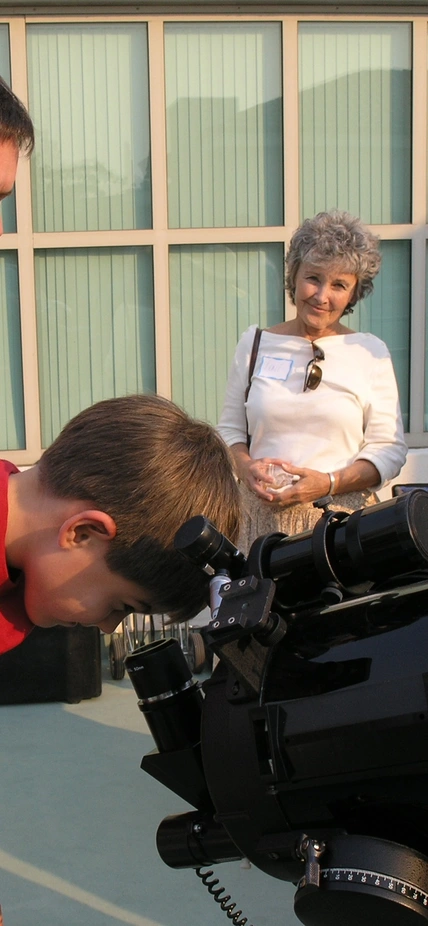 A young Open House attendee looks through a telescope