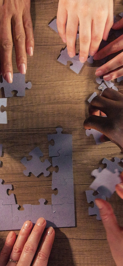 Diverse hands assemble a puzzle