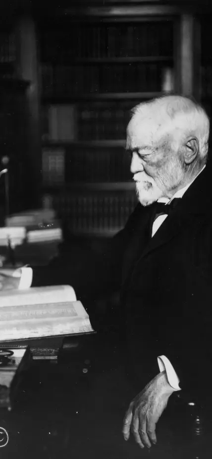 Andrew Carnegie seated at a desk with a book, circa 1913 1913
