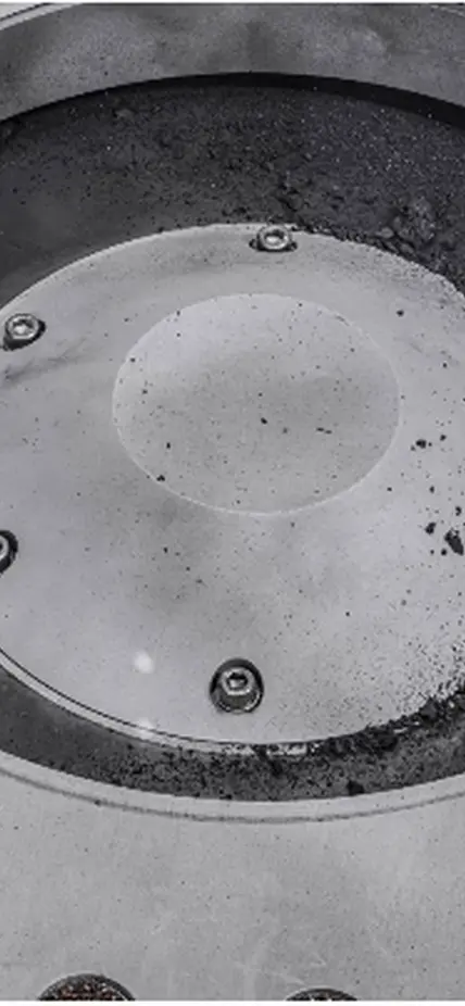 A view of the outside of the OSIRIS-REx sample collector. Sample material from asteroid Bennu can be seen on the middle right. Scientists have found evidence of both carbon and water in initial analysis of this material. The bulk of the sample is located inside. Photo: NASA/Erika Blumenfeld & Joseph Aebersold