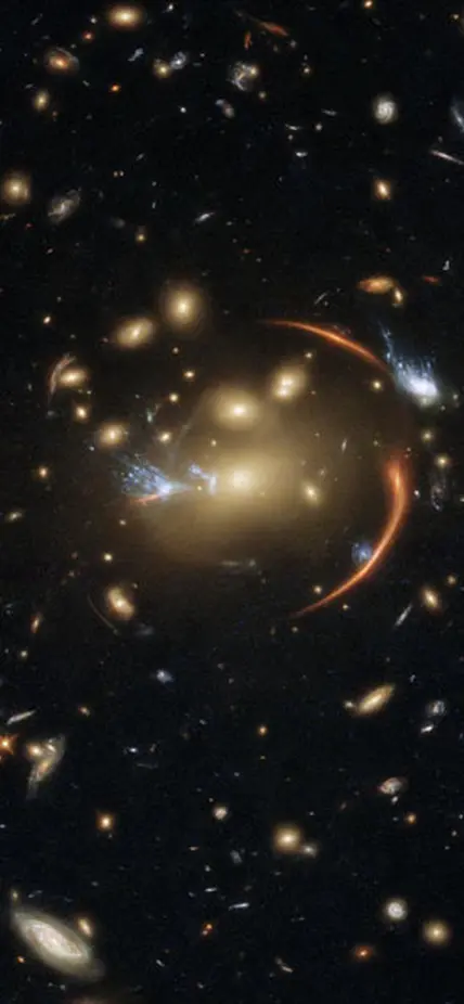 This Hubble image shows the galaxy cluster MACS J0138.0-2155, which is so massive that its gravity bent and magnified light streaming not only from an extremely distant background galaxy but also from a supernova event in this galaxy. The color image was made using observations from eight different filters spread across Hubble’s Advanced Camera for Surveys (ACS) and Wide Field Camera 3 (WFC3). The color results from assigning different hues to each monochromatic image associated with an individual filter. I