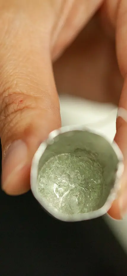 A small silver bucket filled with what looks like glass is the result of a drop quench experiment.