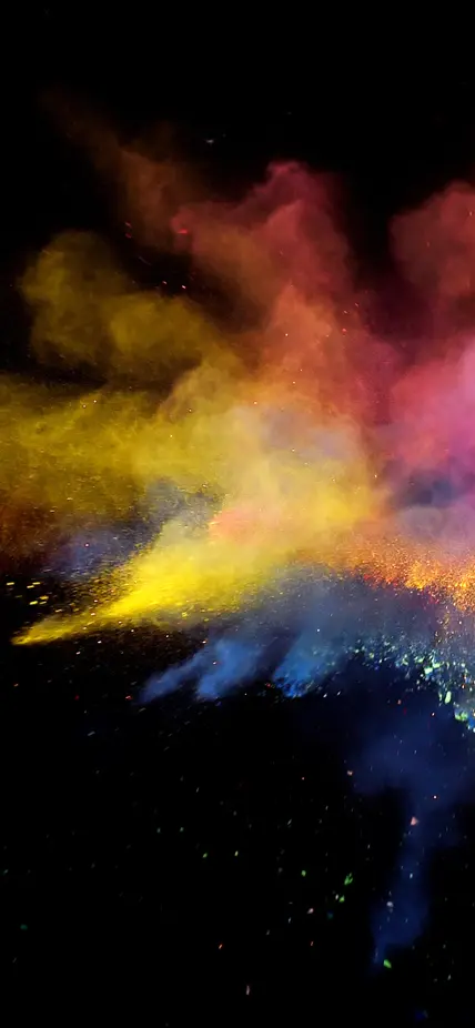 An explosion of rainbow powders on a black background