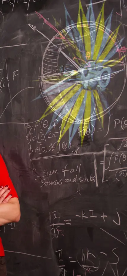 Sarah Seager in front of a blackboard. Photo by Sam Ogden