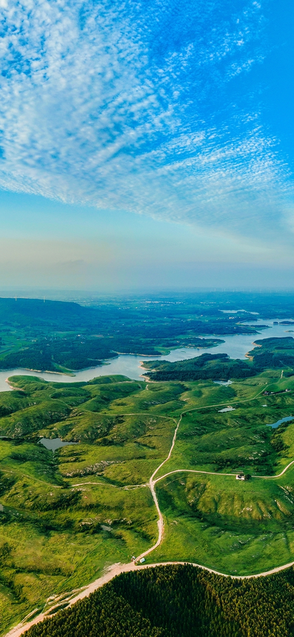 An aerial view of mountains and ocean with the sky in transition