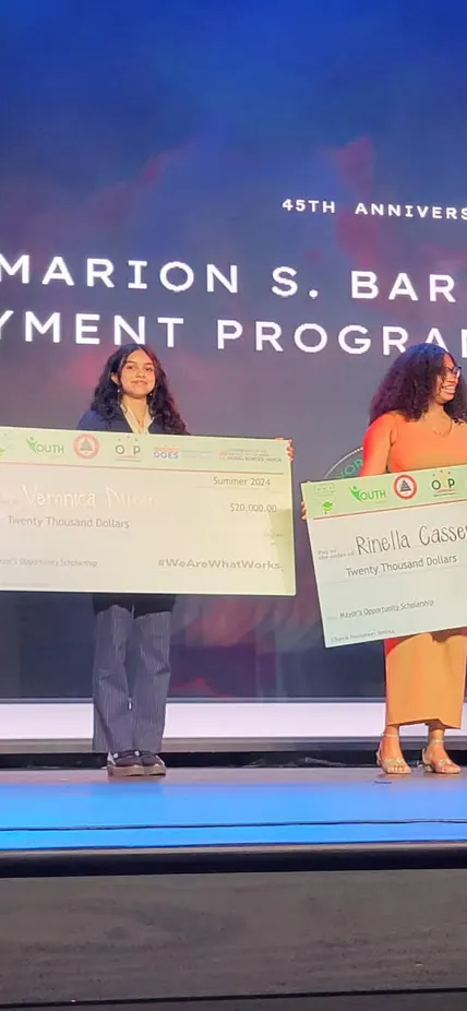 Veronica Duran poses on stage with her 20K check for the Mayor's Opportunity Scholarship