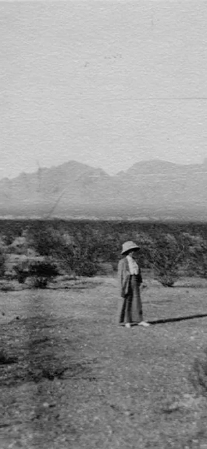 A woman, probably Edith Clements, standing in the desert
