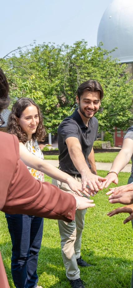 Interns hold hands in before cheering "Science!" 