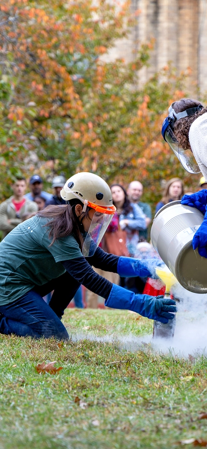 Diana Roman and Andrea Goltz prepare a "trash-cano" at the Earth & Planets Laboratory Open House.