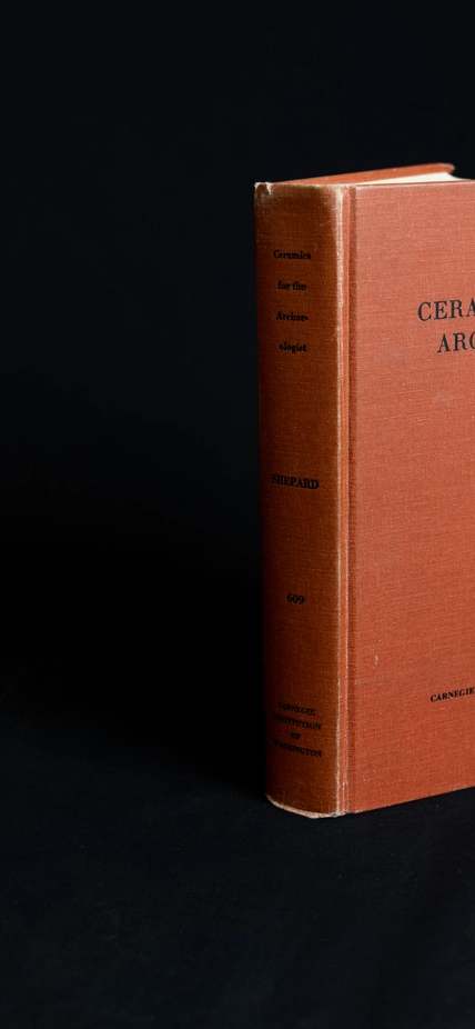 Red book on black backdrop. "Ceramics for the archaeologist"