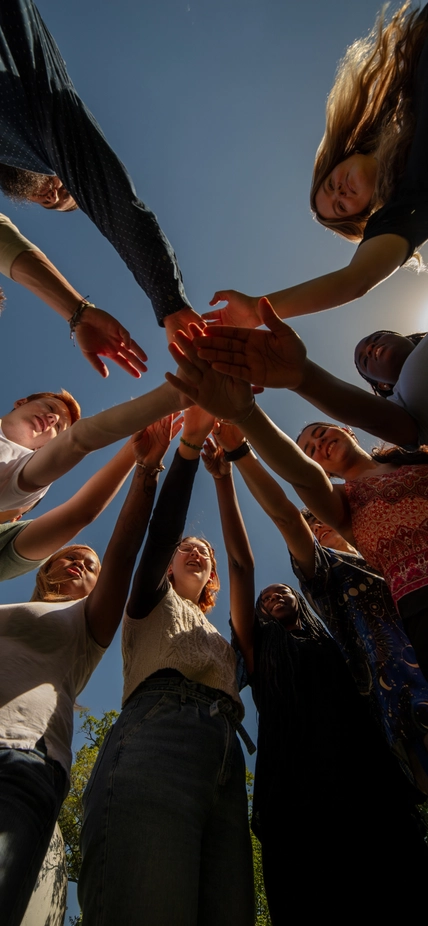Go team on three! Looking up at interns with hands in during an early internship huddle. 