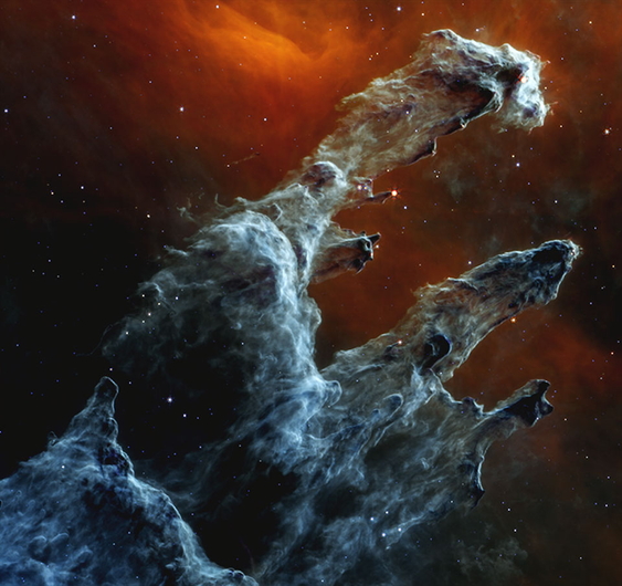 In the Eagle Nebula, towering columns of dust and gas stretch for light-years, cradling clusters of newborn stars.