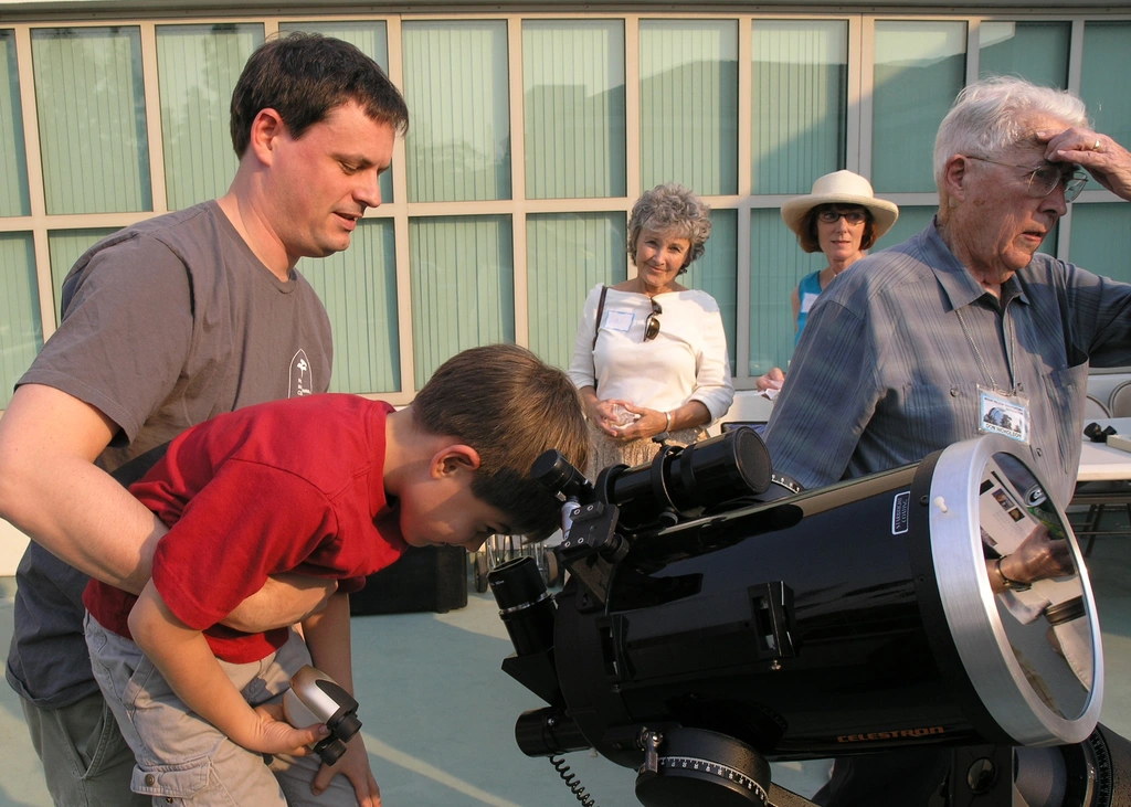 A young Open House attendee looks through a telescope