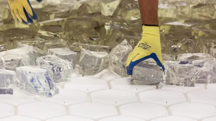 Mirror lab staff set pieces of glass onto the mold for the fifth mirror for the Giant Magellan Telescope