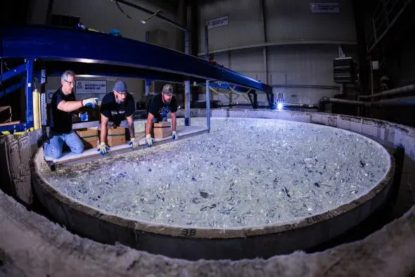Mirror lab staff review the glass placed in the Giant Magellan Telescope mirror mold, checking for space