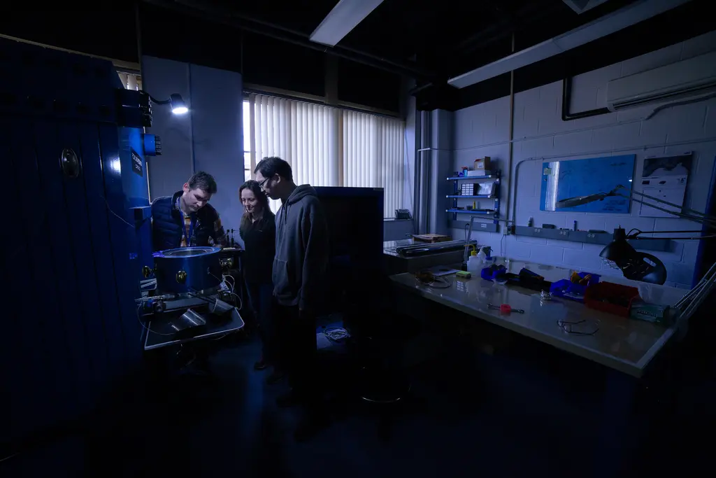 Anne and Engineering Team Troubleshoot Rockland Press in a dramaticly lit laboratory