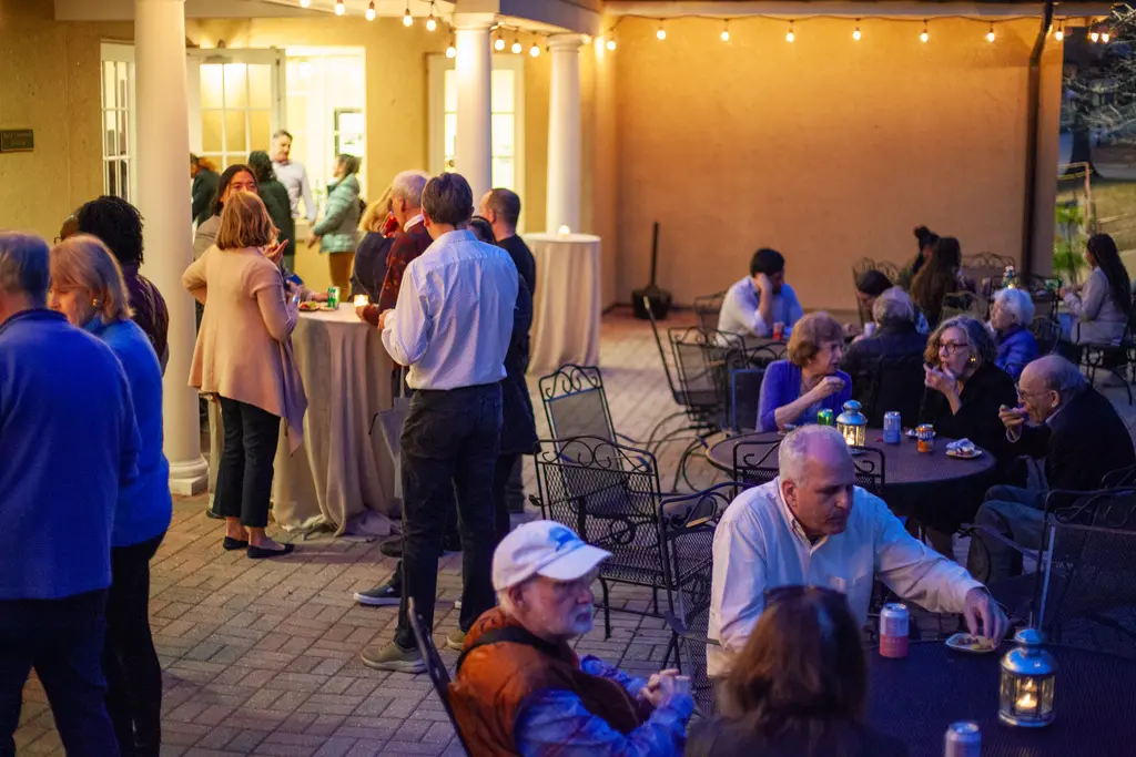 Attendees of Carnegie's The Space Race screening mingle on the Broad Branch Road campus patio, enjoying refreshments