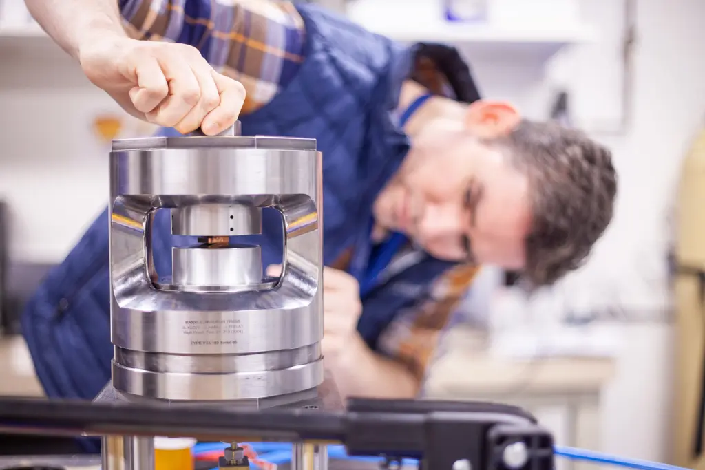 Javier places a copper sample in the press