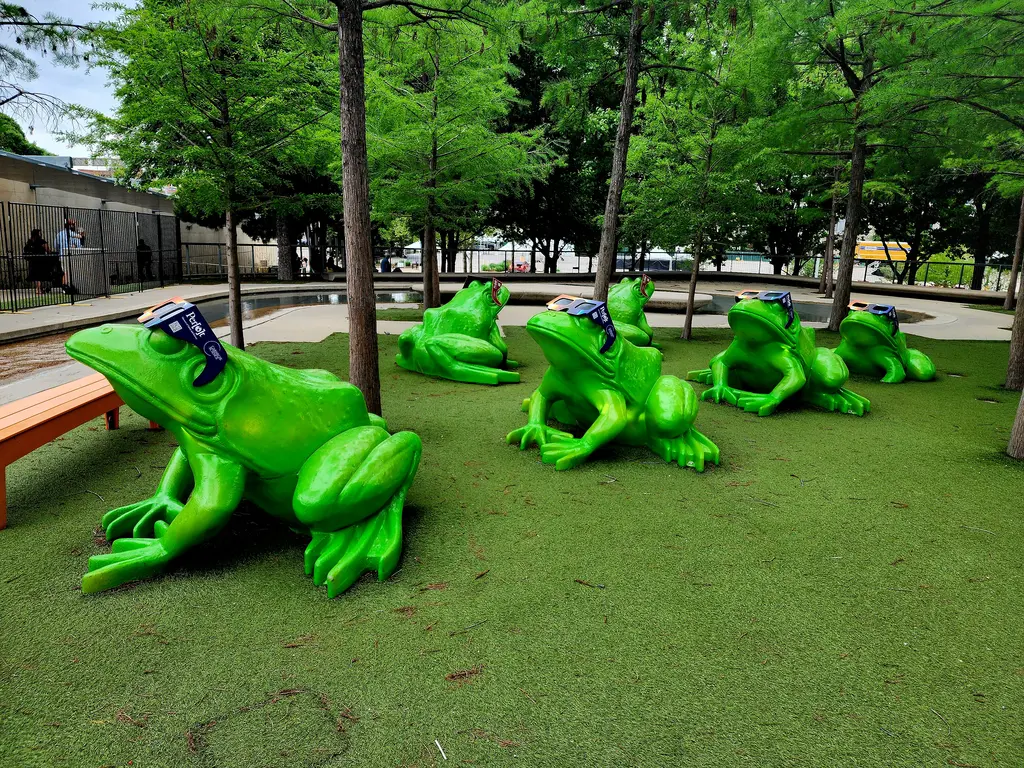 Frogs in front of the Perot Museum of Nature and Science sport eclipse glasses