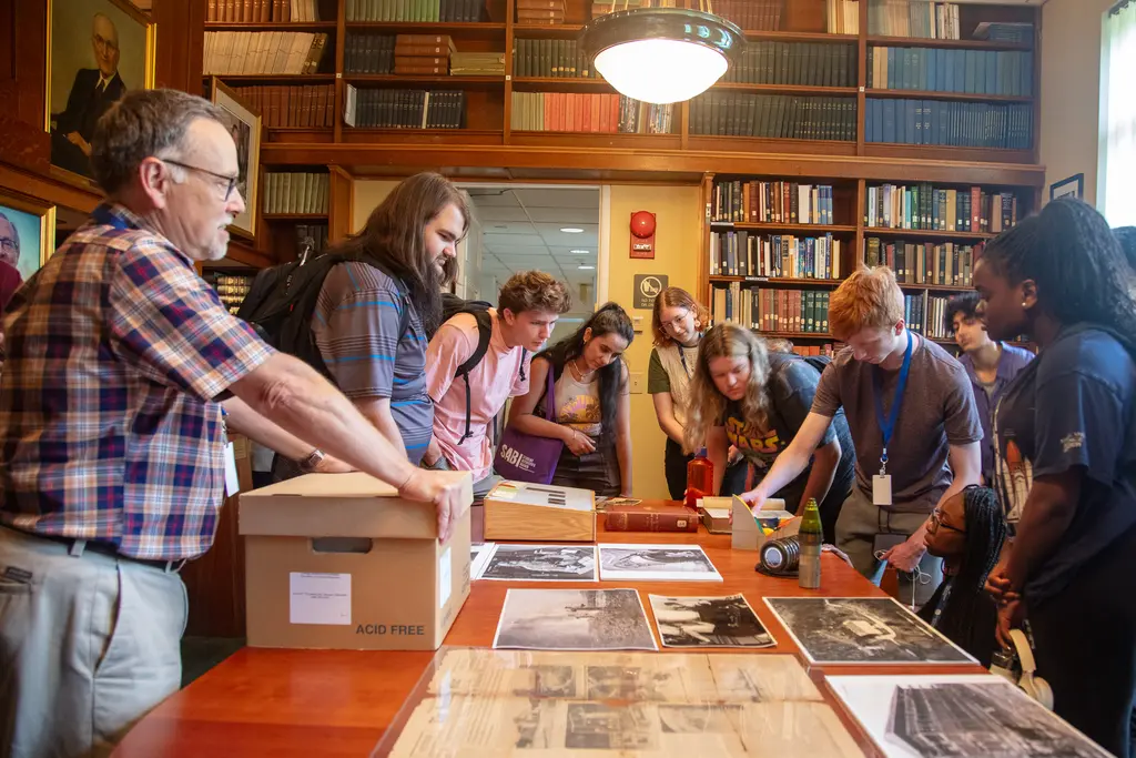 Interns lean over historic materials at the Earth and Planet Laboratory Laboratory 