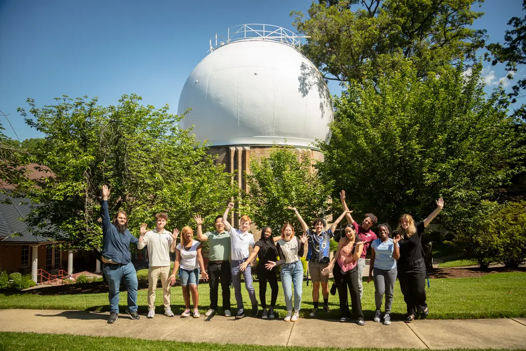 Interns pose for a group photo infront of the Atomic Physics Observatory. 