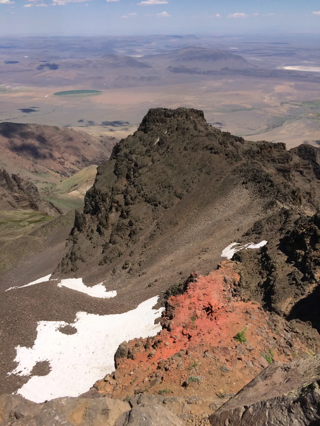 The red layer found between two basalt flows on top of Steens Mountain in Oregon yielded zircons that were dated to constrain the age of the oldest formation of the Columbia River Basalt Group (Photo credit: Jennifer Kasbohm).