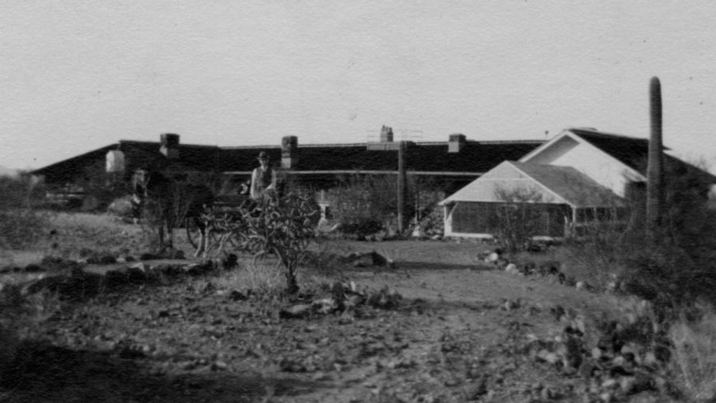 Frederic Clements in a horse-drawn carriage posing for a photograph in front of the Desert Laboratory