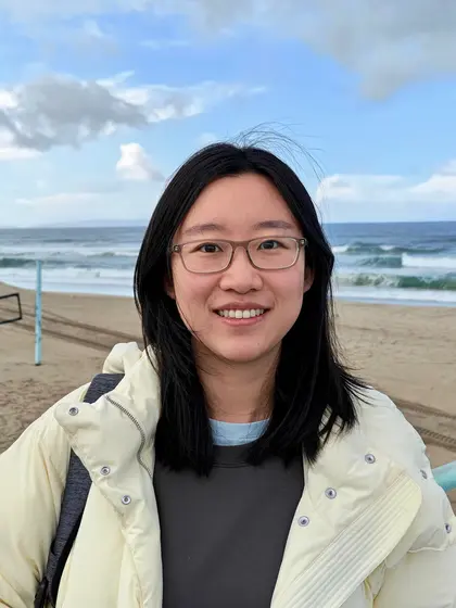 Meng Gu stands in front of the ocean