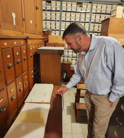 Carnegie Science President John Mulchaey examines solar drawings from Mount Wilson in the Carnegie Science Observatories plate vault. 