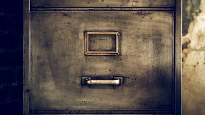 the front of an old file cabinet without a paper label in the metal frame