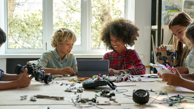 Group of five young students around a table