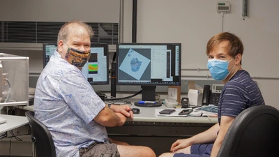 Larry Nittler and Jens Barosch pose for a photo as they scan a sample of the Ryugu asteroid