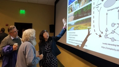 Dr Yixian Zheng Explains Biological Systems to Enthusiastic Neigbhors.jpeg