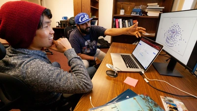 Mike Wong and colleague Anirudh Prabhu discuss how to tweak the presentation of a network of Earth's atmospheric chemistry in their shared office on the Broad Branch Road campus. 