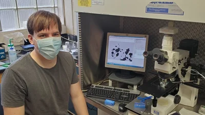 Jens Barosch studies a sample of the Ryugu meteorite under a microscope on campus.