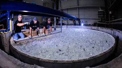 Mirror lab staff review the glass placed in the Giant Magellan Telescope mirror mold, checking for space