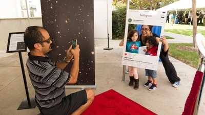 Family poses on the redshift carpet at the Carnegie Observatories Open House