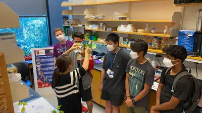 Huiqiao Pan talks to students about soybeans for a BioEYES outreach activity