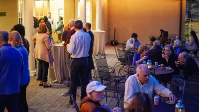 Attendees of Carnegie's The Space Race screening mingle on the Broad Branch Road campus patio, enjoying refreshments