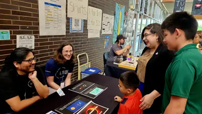 Two Carnegie Science astronomers table at a community event in Dallas