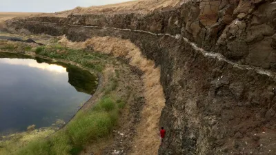 The volcanic ash found between two basalt flows yielded zircons that were dated to constrain the age of a magnetic field reversal and the second-youngest formation of the Columbia River Basalt Group. Princeton University's Josh Murray provides scale (Photo credit: Jennifer Kasbohm).