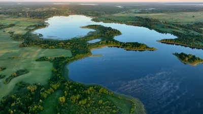 A lake stretches through a green area