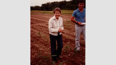 Barbara McClintock standing in a cornfield in 1983