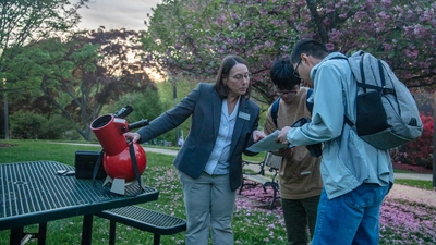ALycia Weinberger uses a table top telescope