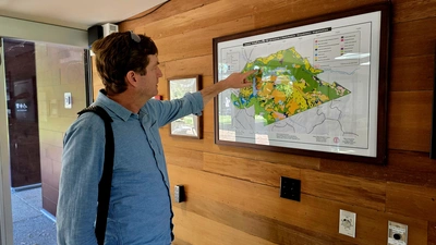 Jeffrey Dukes consults the map on the wall of the Jasper Ridge Biological Field Station